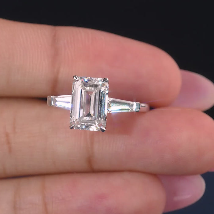 emerald cut engagement ring with trilogy diamond ring.
