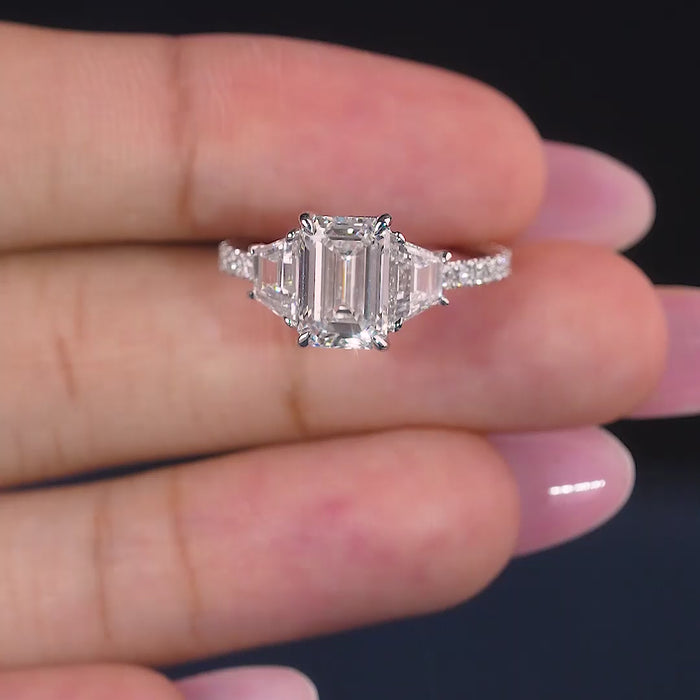  emerald diamond ring with trapezoid side stones.

