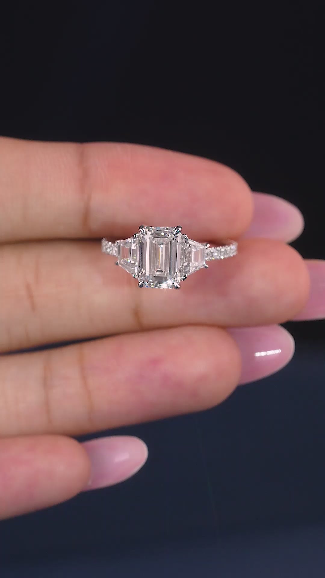 emerald diamond ring with trapezoid side stones.
