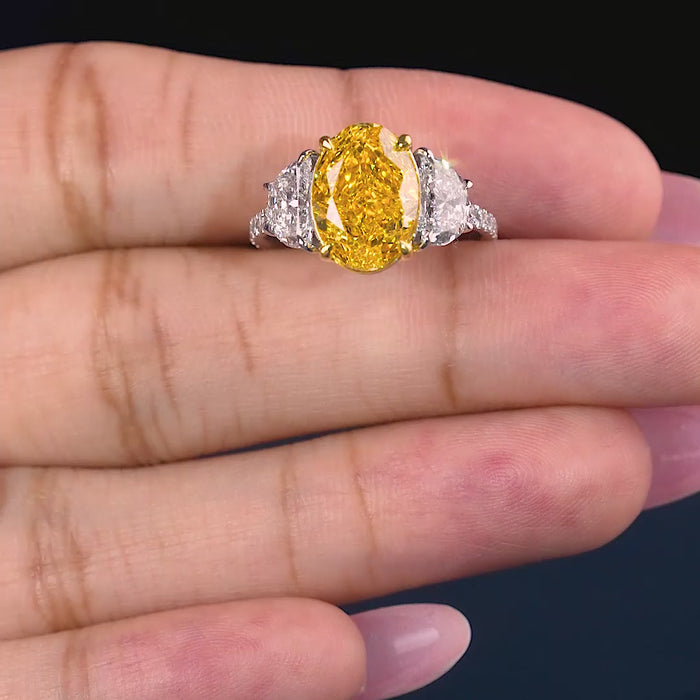 yellow diamond ring with half moon cut side stone.
