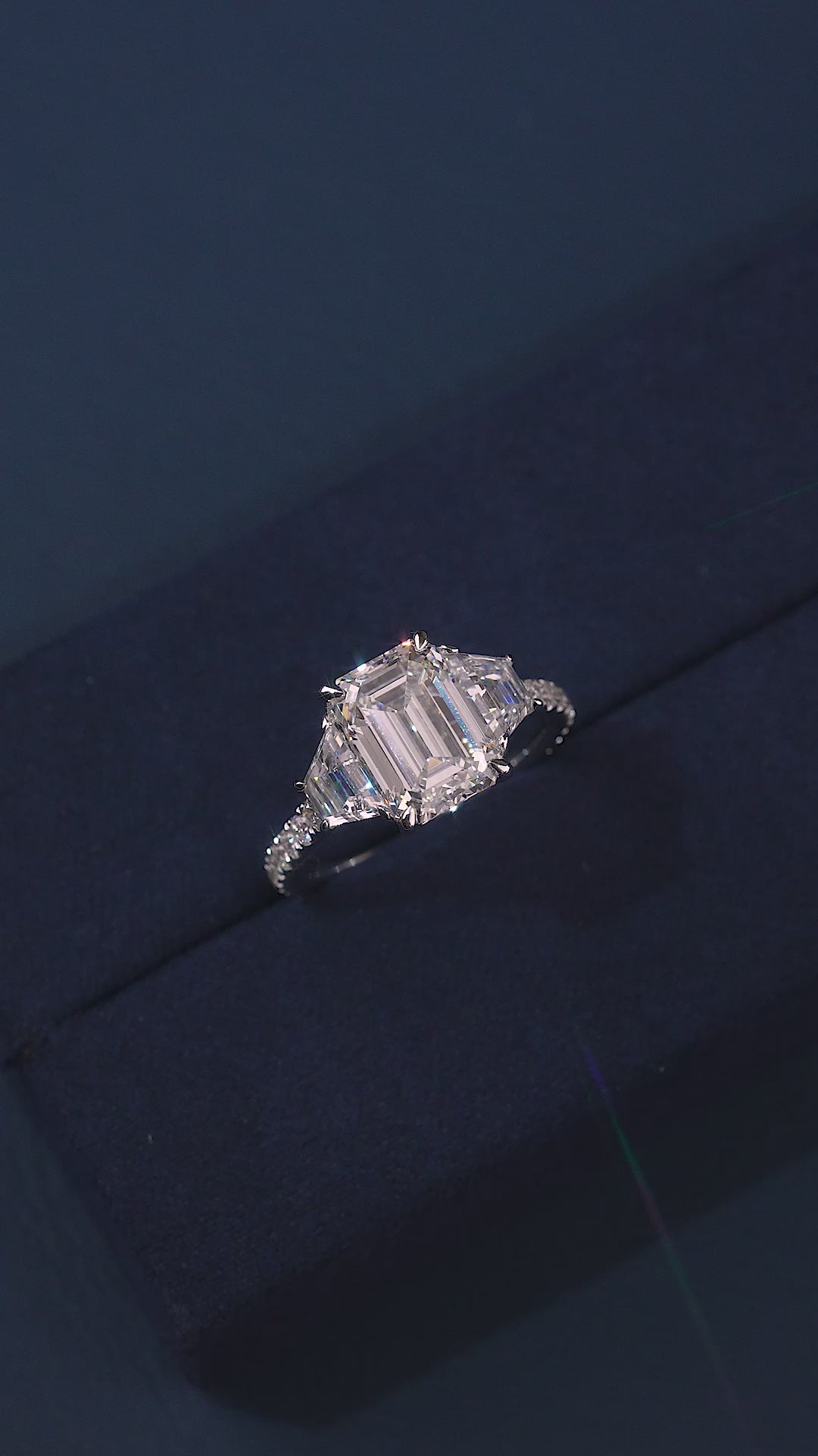 emerald diamond ring with trapezoid side stones.
